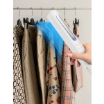 Rack with capsule clothes in beige colors on the white background closeup.