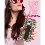 Positive attractive young brunette female person wearing stylish pink shirt grey hat and colourful sunglasses isolated over pink background holding in hand and showing mobile phone with empty display for mockup looking up